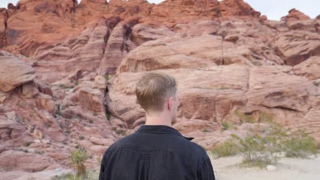 young caucasian man walking in slow motion in red rock canyon national conservation area in nevada, usa