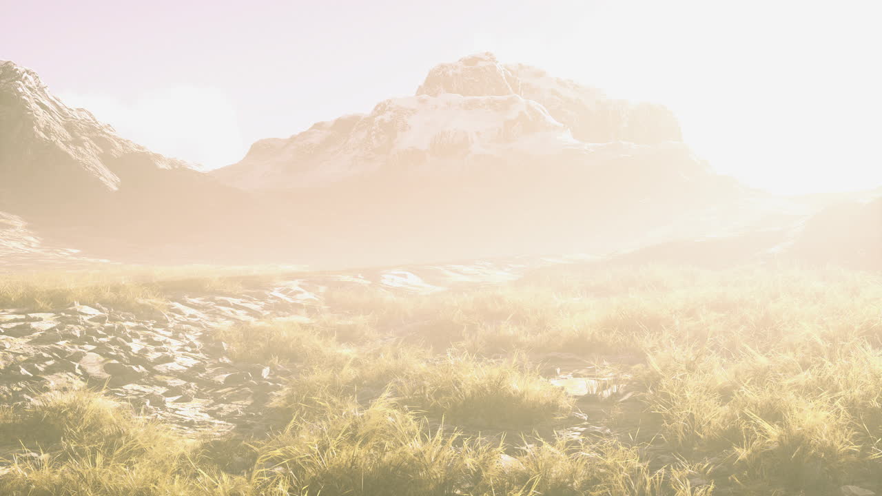 Mountain landscape bathed in soft light with grass and distant peaks