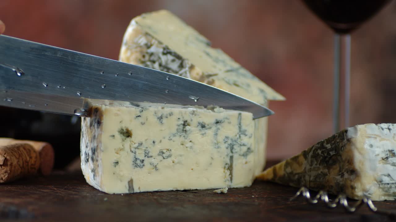 큰 칼로 브리 치즈 한 조각을 잘라냈어요.