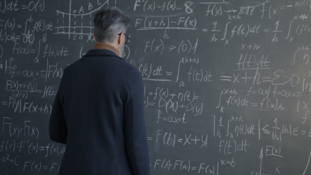 Teacher writing equations on a chalkboard