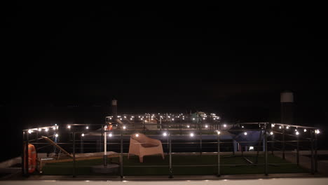 nighttime view of illuminated pier with decorative lights and empty seating area for relaxation