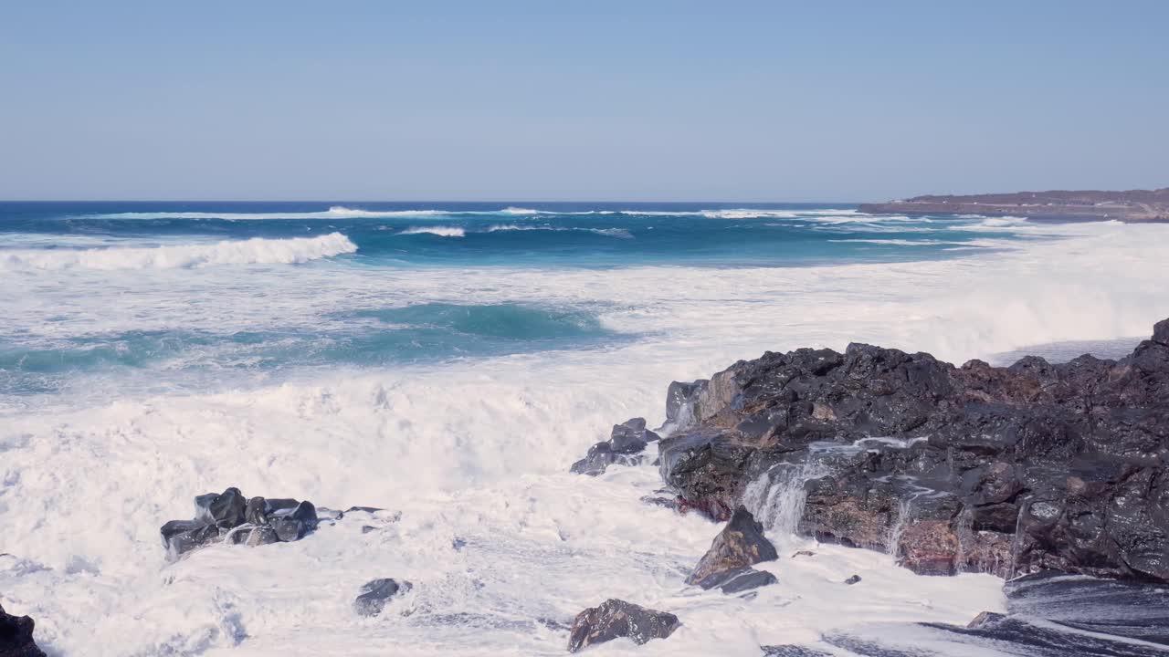 fuertes olas chocando contra las rocas volcánicas