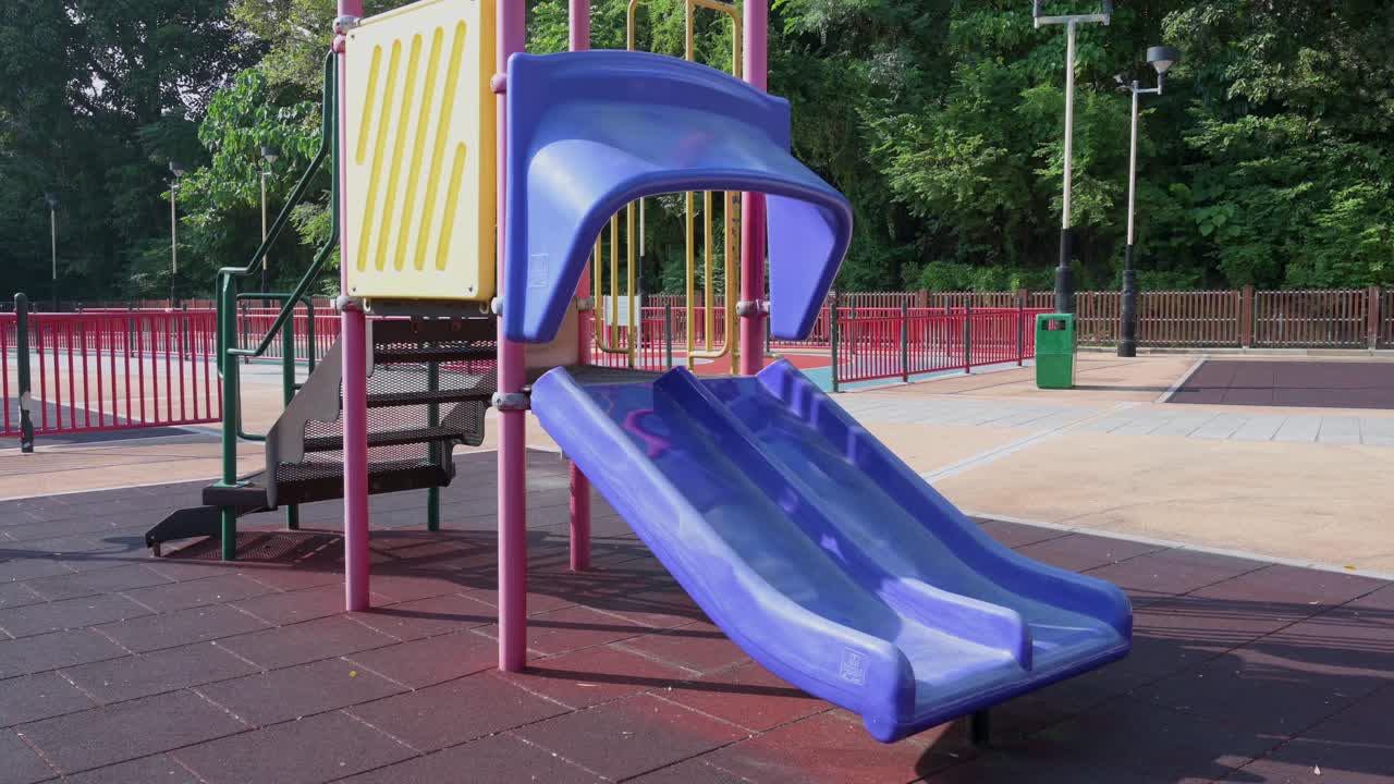 se ve un tobogán morado vacío en un parque infantil en un parque en hong kong