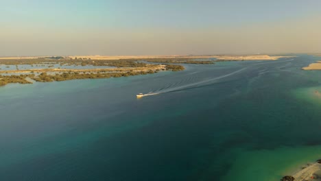 drone aerial white power boat sails across tropical river water middle east