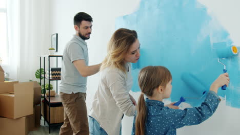 family painting a wall together at home