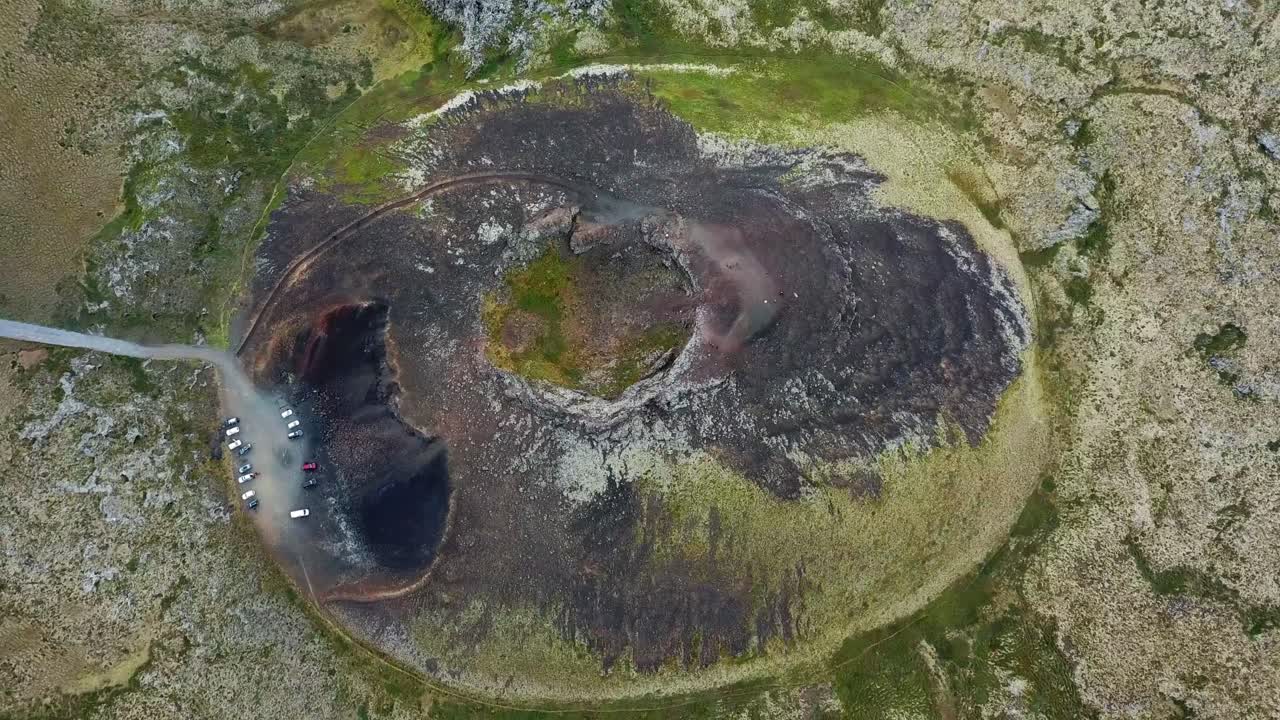 Aerial view of the Saxholl Crater in Iceland, showcasing volcanic formations, geological features, a parking area at the base, highlighting unique volcanic landscape of the region, top down drone shoy