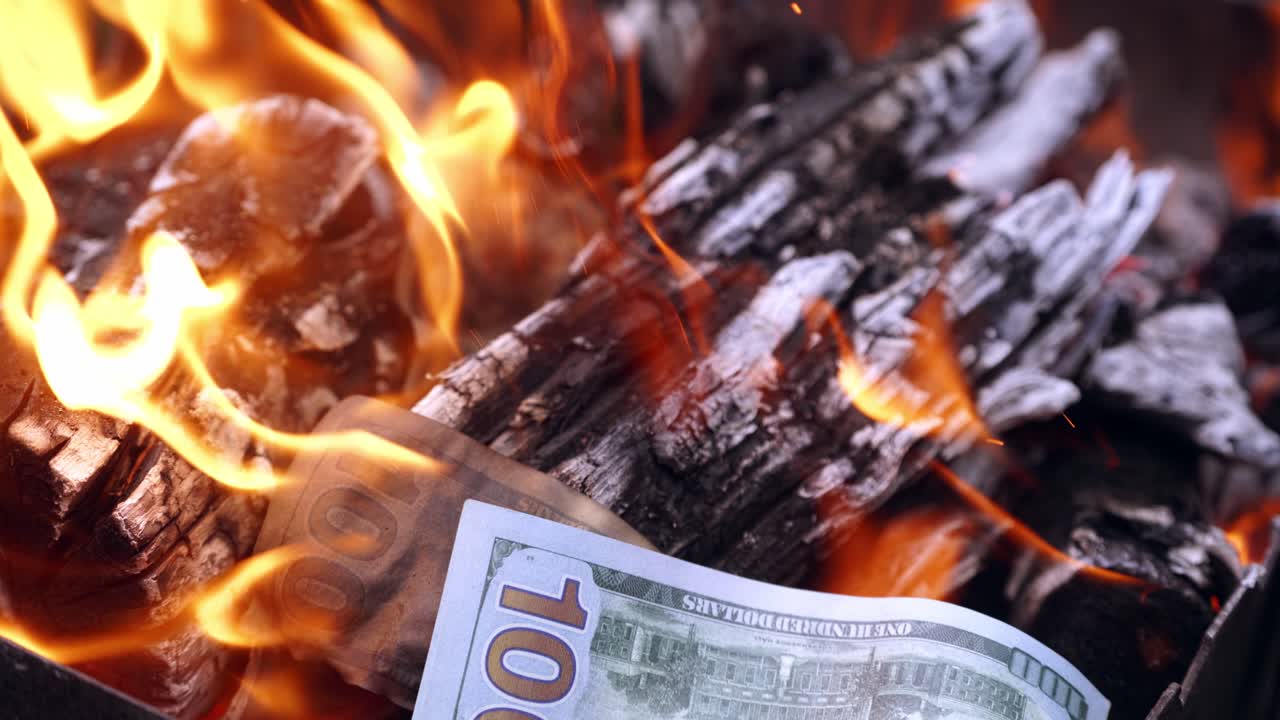 View of money on fire. Hundred dollars burn in a fire