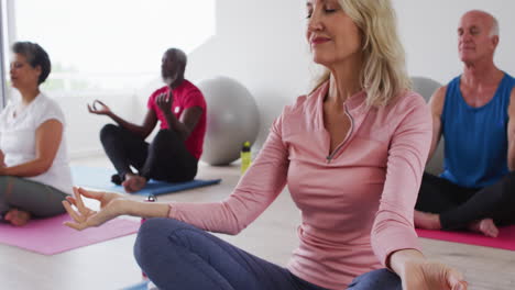 diverse group of seniors taking part in meditation class