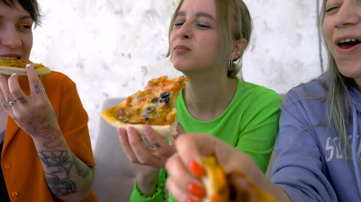 Primo piano di amici che si divertono e mangiano pizza