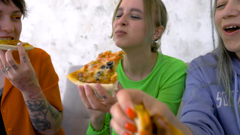 closeup view of friends having a good time and eating pizza