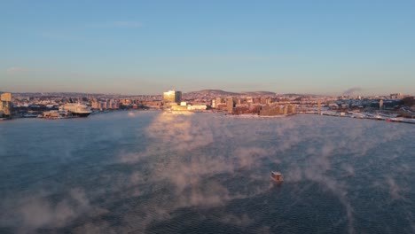 golden hour view over bjorvika in sentrum borough of oslo, norway with fog floating over water