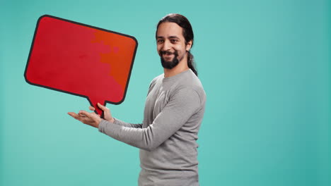 smiling man presenting red speech bubble sign of empty copy space for message