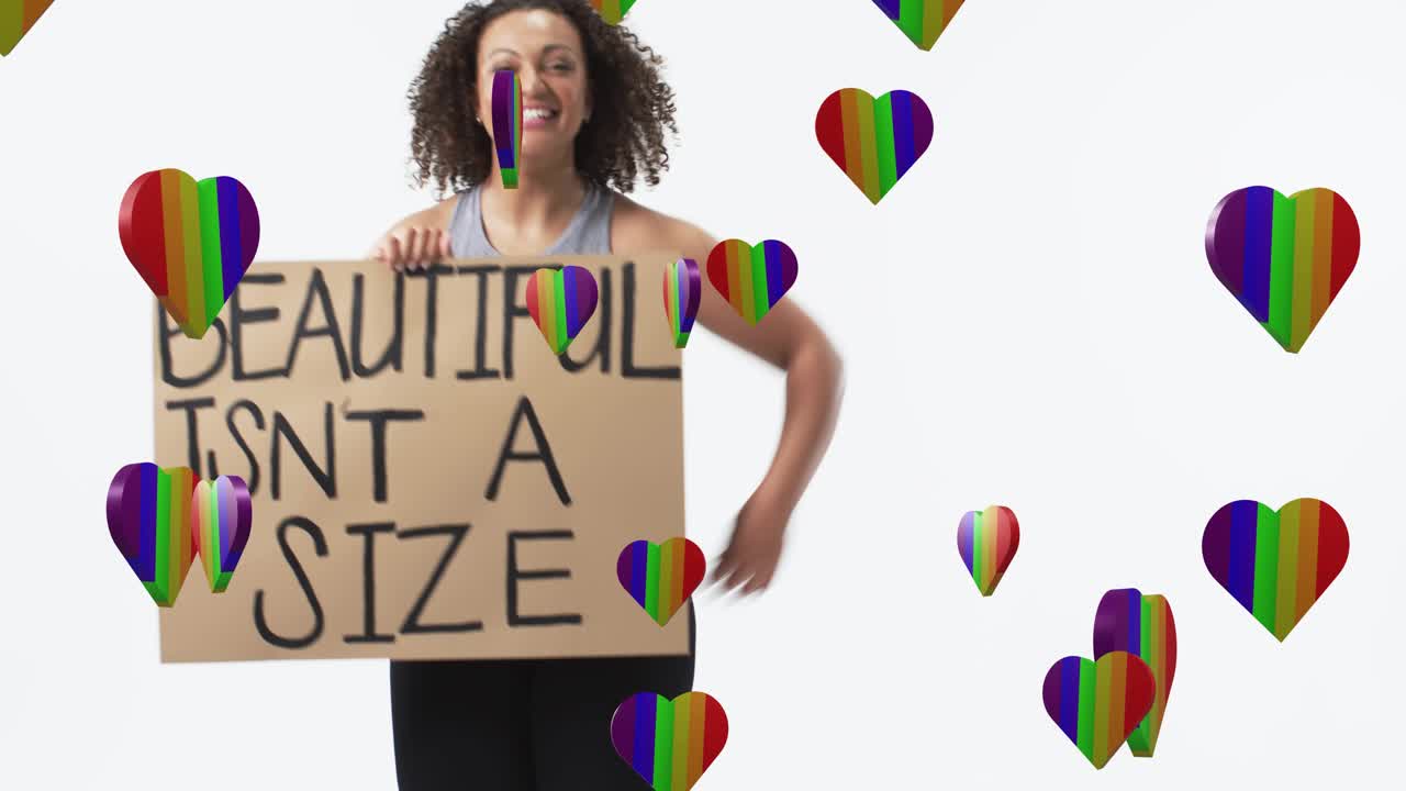 Woman holding sign raising arm and flexing as rainbow hearts drifting over sign for body positivity