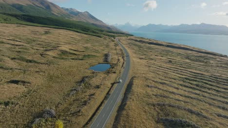 aerial view of tourist campervan traveling in the south island of new zealand aotearoa on beautiful scenic road through aoraki mount cook national park