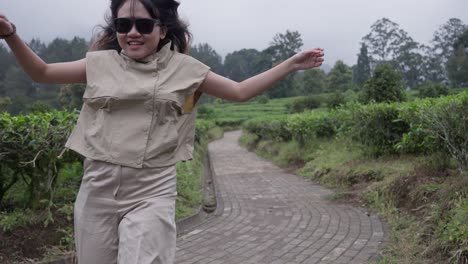 asian girl runs joyfully down a path, her hands moving excitedly