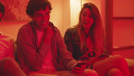 medium shot of girl sitting on couch with friends and yawning