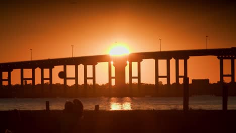 una hermosa puesta de sol tropical en una playa sobre un gran puente