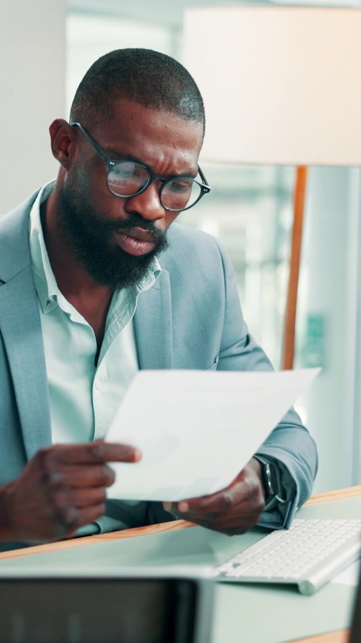 Focused Businessman Reviewing Documents in Modern Office