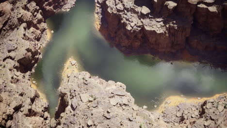 exploring the winding river amidst rugged canyon landscapes in daylight