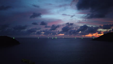 amplia vista panorámica y panorámica cerrada sobre la tranquila zona de la bahía del océano tropical con un espectacular paisaje nublado de cúmulos azules, morados y dorados al atardecer de un día de monzón tropical