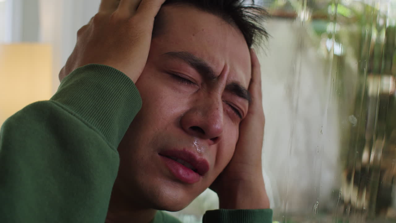 창문에 머리를 기대고 있는 남자