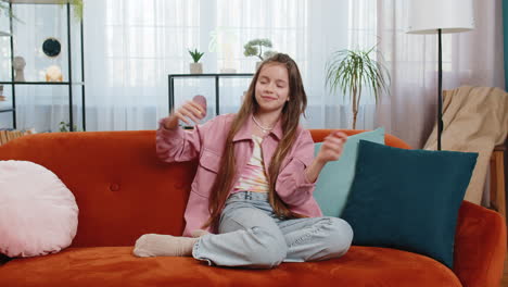 alegre niña positiva niño divirtiéndose bailando celebrando la victoria moviéndose al ritmo de la música en la habitación de casa