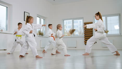 kids in white kimono in martial arts class