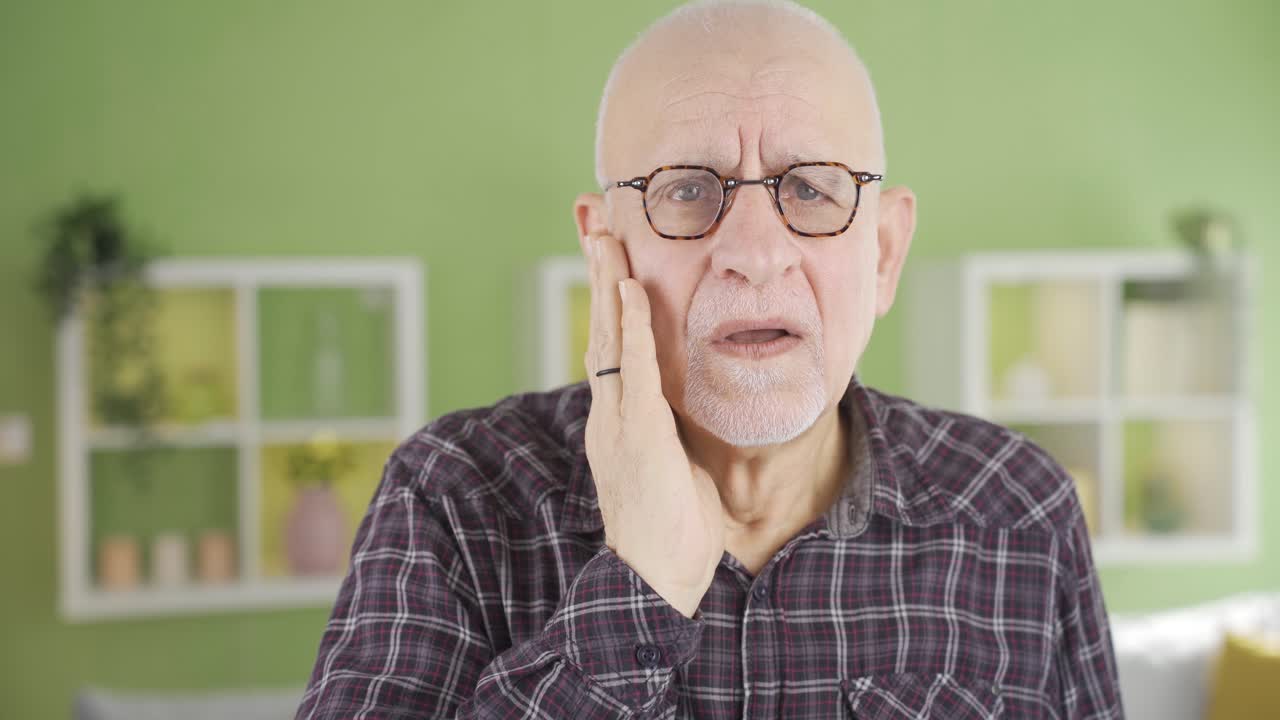 Looking at the camera confused, the old man receives bad news and gets upset.