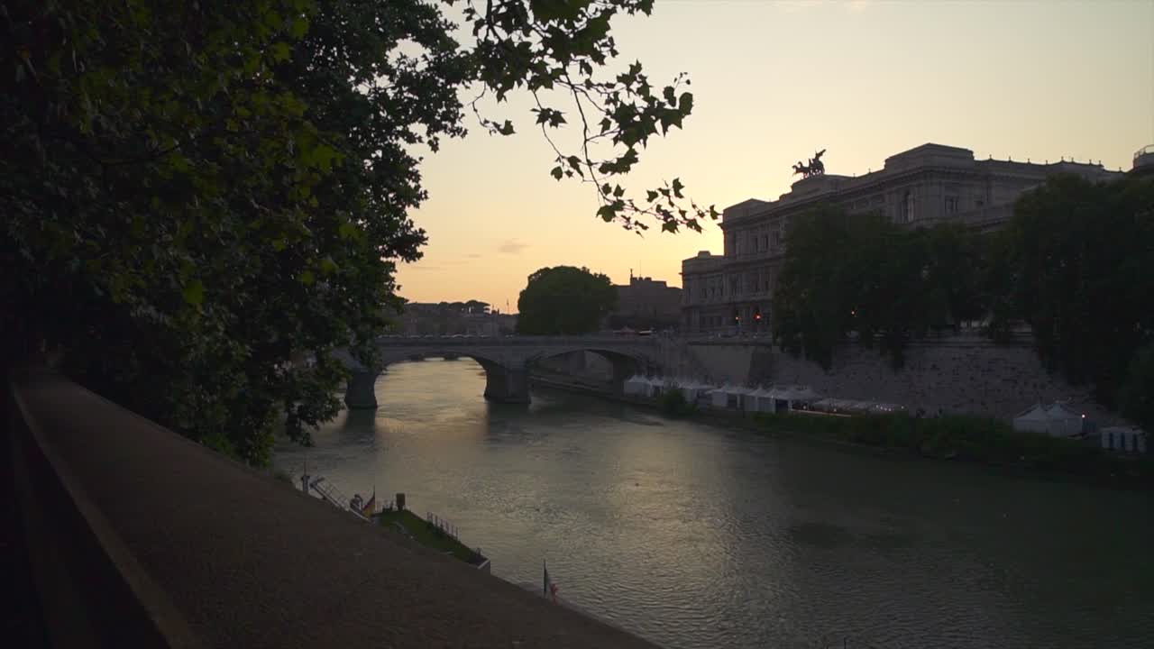 River Tiber running through Rome city at dusk. Wide shot, dolly