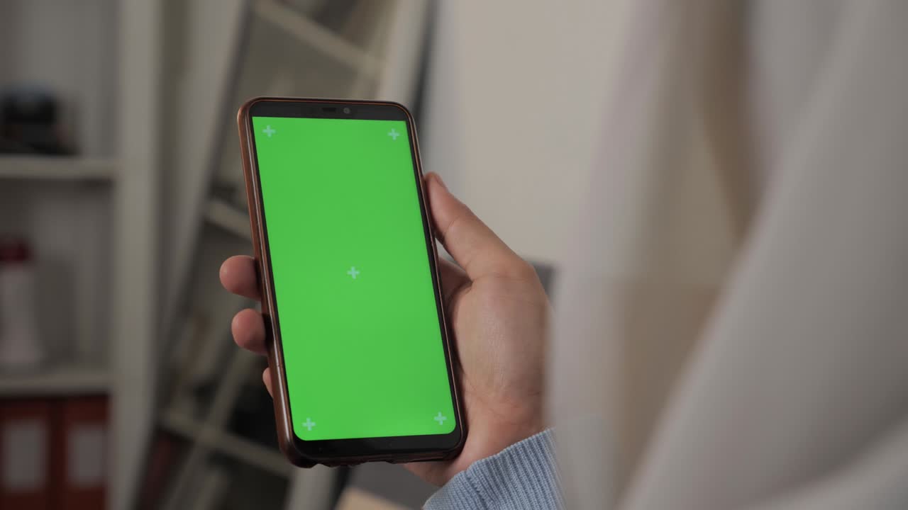 Close up image of smart phone mockup, woman holding phone with green screen