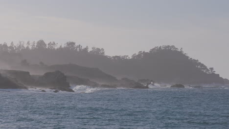 slow motion shot of the ocean with foggy mountains background located in monterey bay marina state beach california