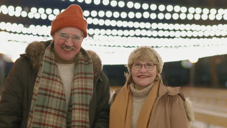 elderly couple ice skating at night