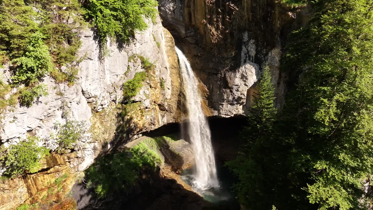 Beautiful Berglistüber waterfall in Glarus Süd, Klausenpass, Switzerland, aerial nature view with rocks, forest and clear falling water