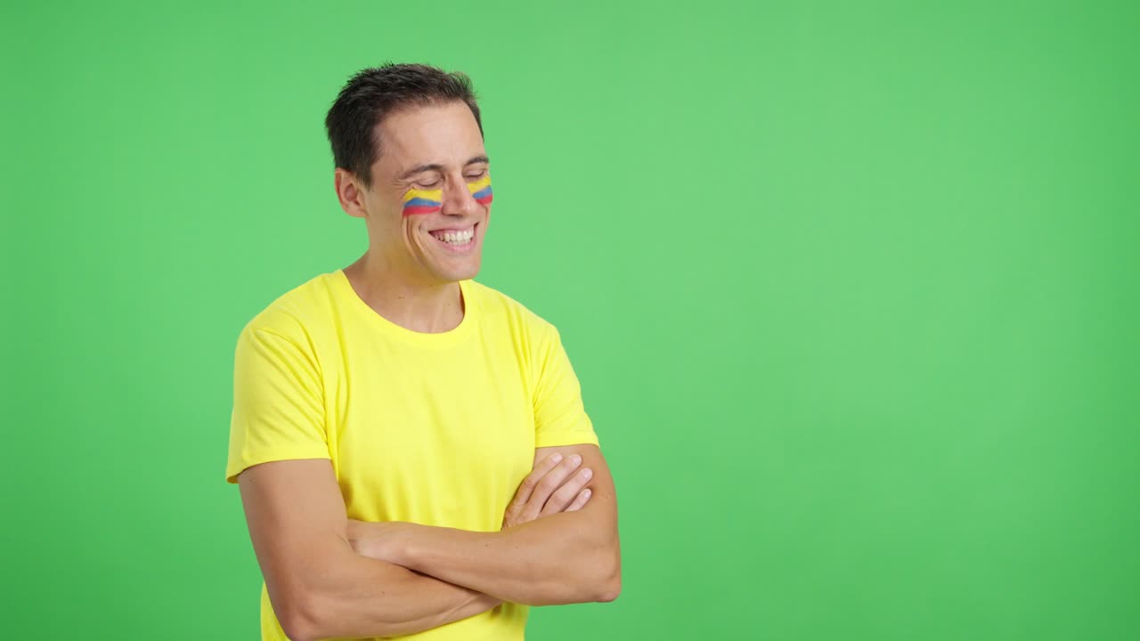 Hombre feliz con la bandera colombiana pintada en la cara mirando hacia otro lado