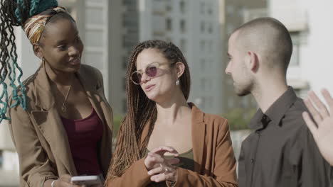 medium shot of happy coworkers standing outdoor and talking