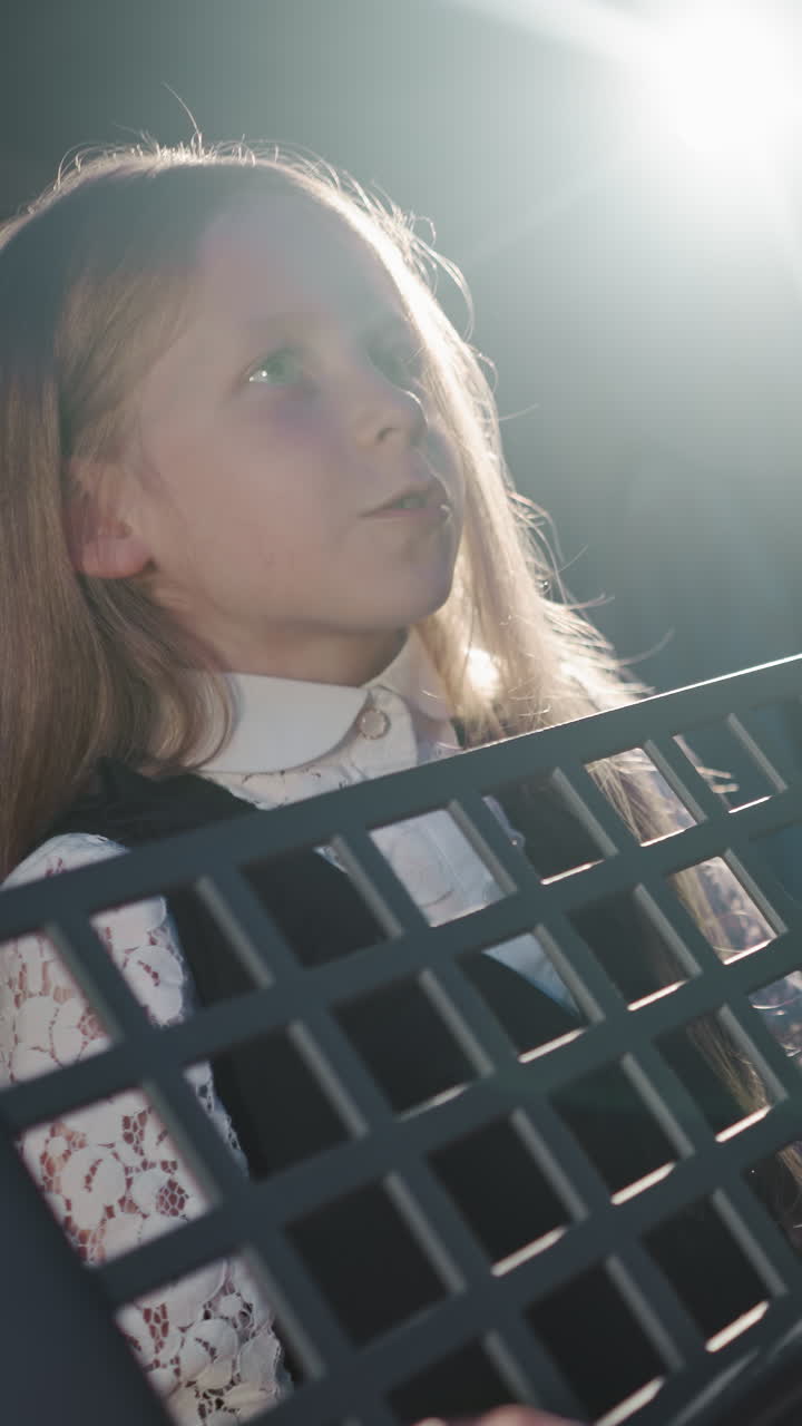 아이는 교육자와 함께 노래하는 기술을 이해합니다. 어린 소녀 학습자는 음악 스튜디오에서 배경 조명에 대항하여 교사와 함께 보컬 기술을 날카롭게합니다. 음악 훈련