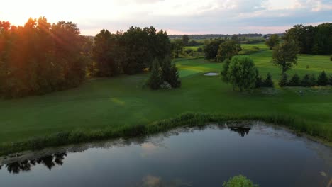 beautiful drone shot of large green golf course at sunset in canada