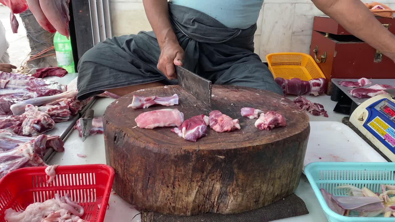 En lokal slaktare i Indien skär getkött i små bitar för försäljning