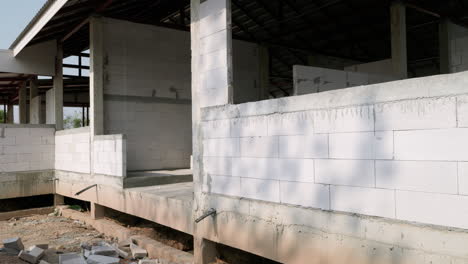 Panning-from-the-left-to-the-right,-showing-a-building-under-construction-in-the-outskirts-of-Bangkok,-Thailand