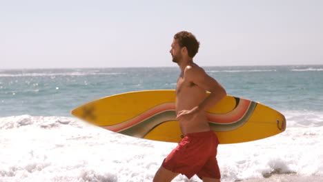 un hombre está corriendo con su tabla de surf