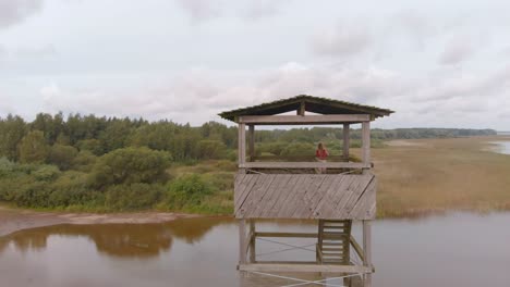 woman birdwatching at watchtower vortsjarv lake estonia