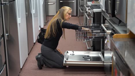 Una-Revelación-Que-Muestra-A-Una-Mujer-Rubia-Bastante-Madura-Mirando-Lavavajillas-En-Una-Tienda-De-Electrodomésticos-De-Cocina