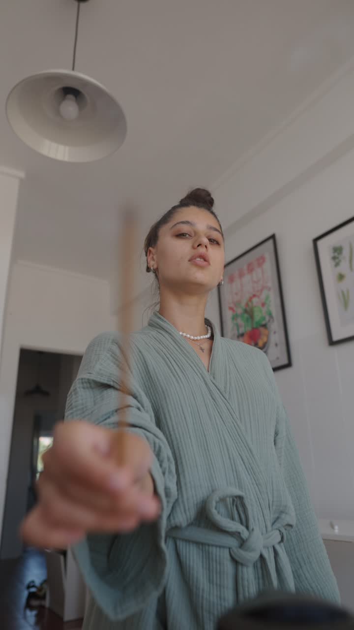 Woman with incense stick in the kitchen