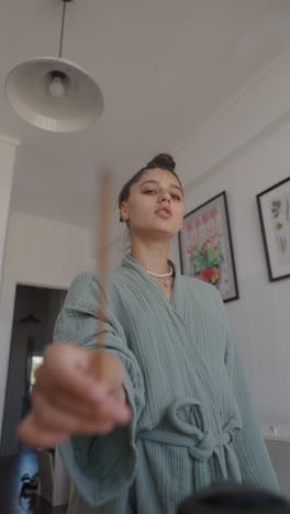 woman with incense stick in the kitchen