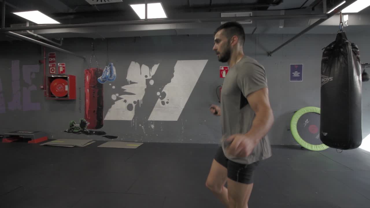 joven atlético saltando una cuerda en el gimnasio
