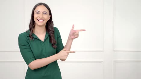 mujer india apuntando a la derecha en el espacio de copia