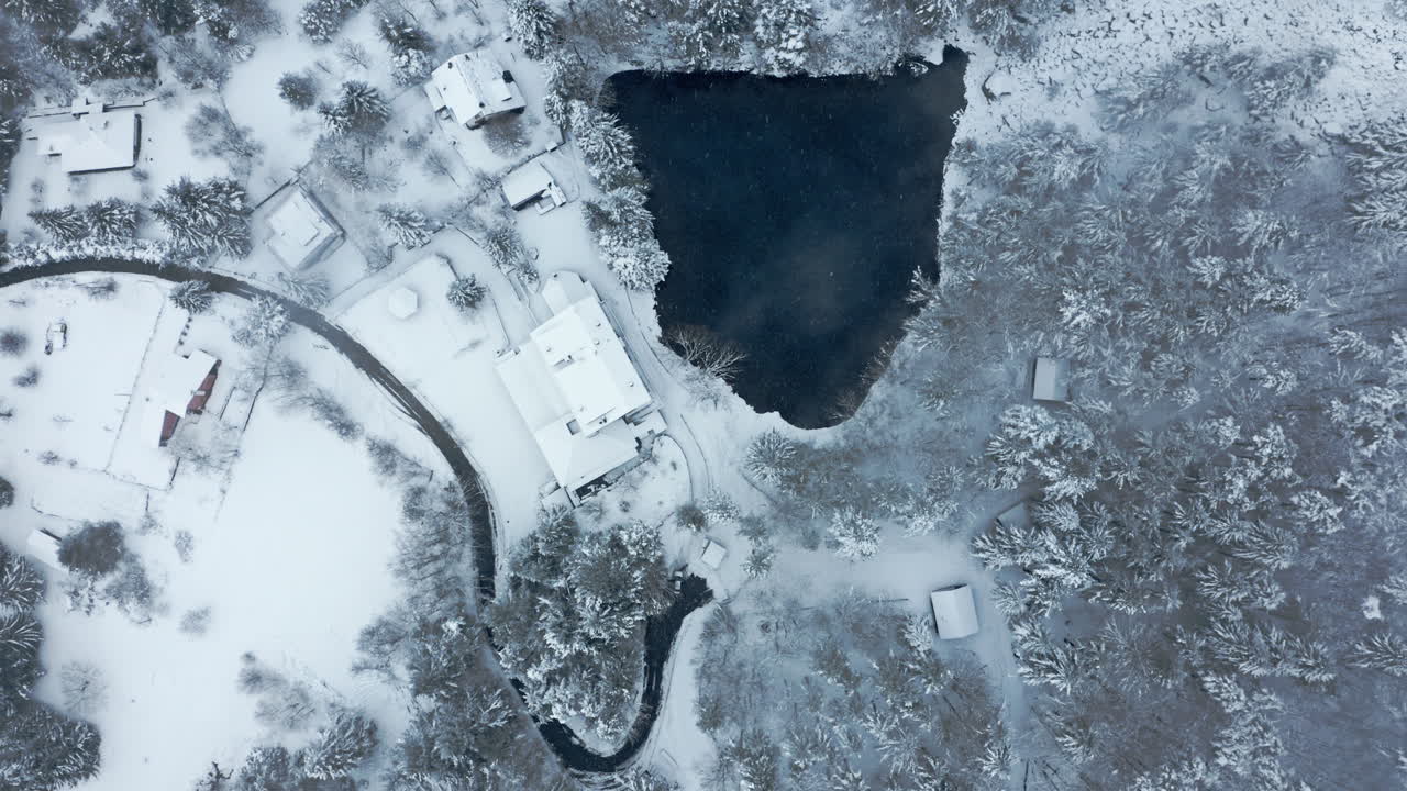 заснеженные деревенские дома у замерзшего озера, спокойный вид с воздуха в зимней тишине