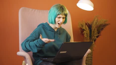 young woman closing laptop with angry expression.