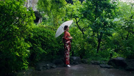 woman in kimono in a japanese garden during rain