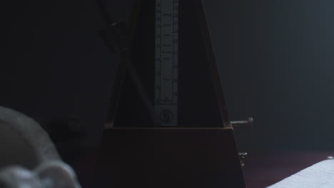 Metronome set the rythm in the dark, old room
